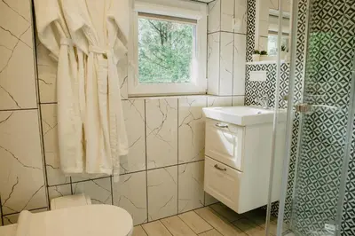 a bathroom with a toilet and a sink and a window at Atokampis Boutique SPA & Resort in Anglininkai