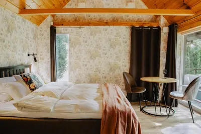 a bedroom with a bed and a table and chairs at Atokampis Boutique SPA & Resort in Anglininkai
