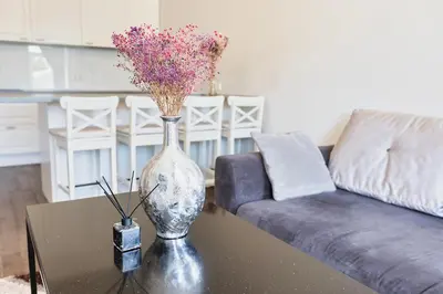a vase with flowers on a table in a living room at Central Stylish Well Equiped Apartments - Self Check-in in Vilnius