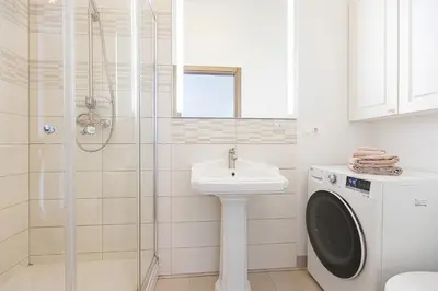 a bathroom with a washing machine and a sink at Central Stylish Well Equiped Apartments - Self Check-in in Vilnius