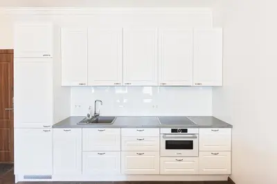 a white kitchen with white cabinets and a sink at Central Stylish Well Equiped Apartments - Self Check-in in Vilnius