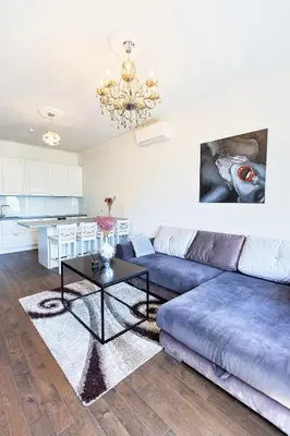 a living room with a blue couch and a table at Central Stylish Well Equiped Apartments - Self Check-in in Vilnius