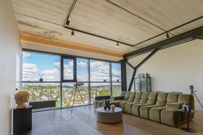 a living room with a couch and a large window at HOUSE38 Panoramic View Apartments SELF CHECK-IN in Kaunas