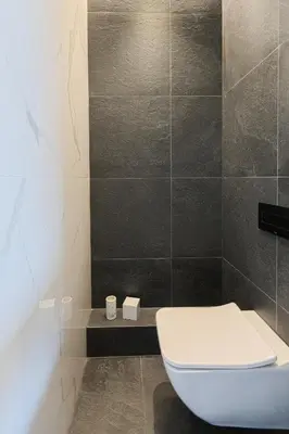 a bathroom with a white toilet and a shower at HOUSE38 Panoramic View Apartments SELF CHECK-IN in Kaunas
