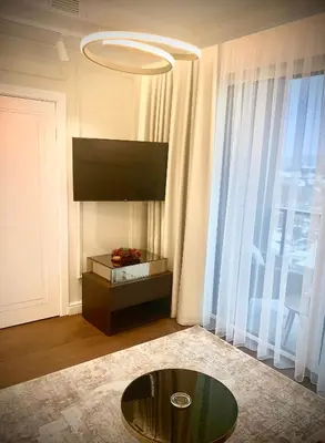 a living room with a table and a large window at New luxury apartment & free parking in Vilnius