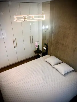 a bedroom with a large bed with white cabinets at New luxury apartment & free parking in Vilnius