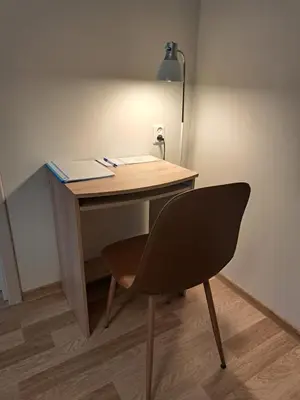 a desk with a chair and a lamp in a room at Sweet home in Šiauliai