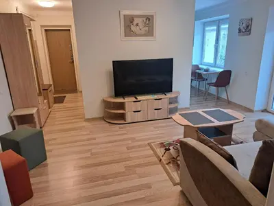 a living room with a flat screen tv on a cabinet at Sweet home in Šiauliai