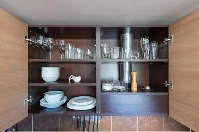 a cupboard with plates and dishes in it at Panoramic city centre apartment by Polo Apartments in Kaunas