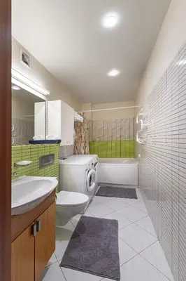 a bathroom with a sink and a washing machine at Panoramic city centre apartment by Polo Apartments in Kaunas
