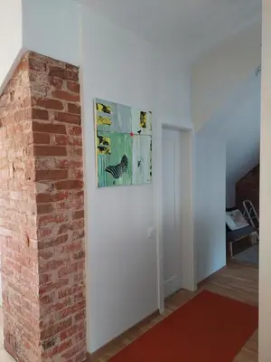 a room with a brick wall and a painting on the wall at Maple Park Apartment in Kaunas