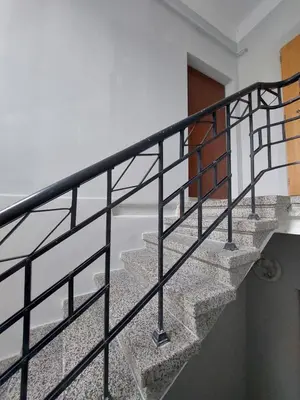 a staircase with black railings in a house at Maple Park Apartment in Kaunas