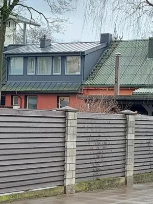 a house with a fence in front of a house at Maple Park Apartment in Kaunas