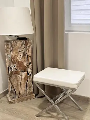a white chair sitting next to a table with a lamp at Kaunas Old Town Apartment in Kaunas