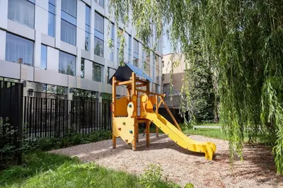 a playground with a slide in front of a building at Luxury apartment in Gediminas avenue with terrace in Vilnius
