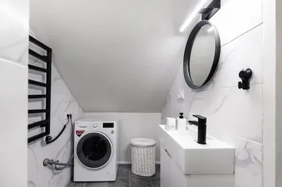 a bathroom with a washing machine and a mirror at Luxury apartment in Gediminas avenue with terrace in Vilnius