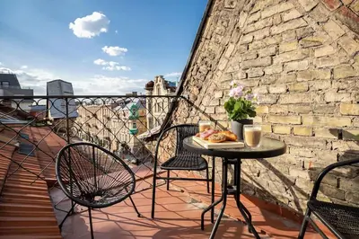 a table with a plate of food on a balcony at Luxury apartment in Gediminas avenue with terrace in Vilnius