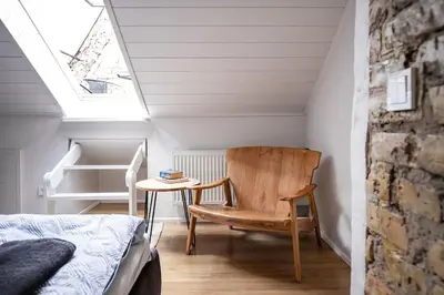 a bedroom with a bed and a chair and a table at Luxury apartment in Gediminas avenue with terrace in Vilnius