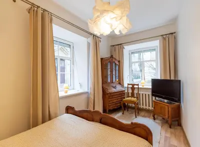 a bedroom with a bed and a tv and a window at Doma3 Luxury Vilnius Apartment in Vilnius