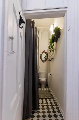 a bathroom with a toilet and a black and white checkered floor at Doma3 Luxury Vilnius Apartment in Vilnius