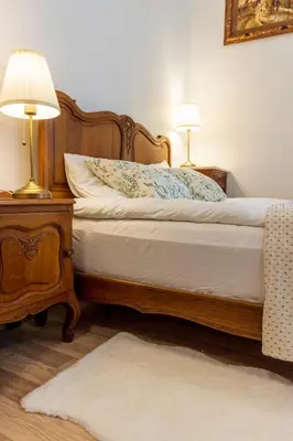 a bedroom with a bed and two lamps on a table at Doma3 Luxury Vilnius Apartment in Vilnius