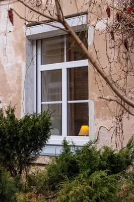 a window of a building with a yellow lamp in it at Doma3 Luxury Vilnius Apartment in Vilnius