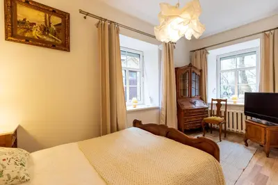a bedroom with a bed and a tv and a window at Doma3 Luxury Vilnius Apartment in Vilnius