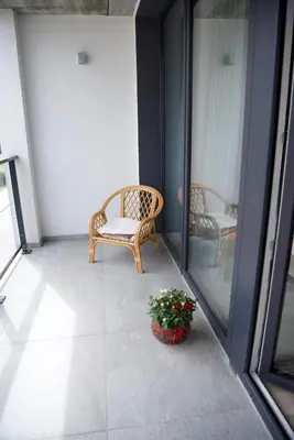 a balcony with a chair and a potted plant at J. Ralio apartamentai (monkey) in Vilnius
