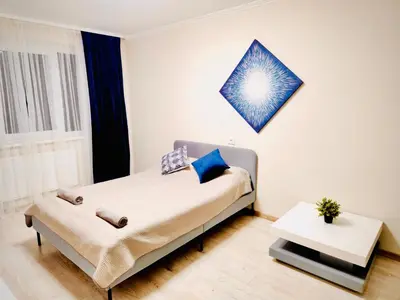 a bedroom with a bed and a table at M&M Apartment V SELF CHECK-IN in Panevėžys