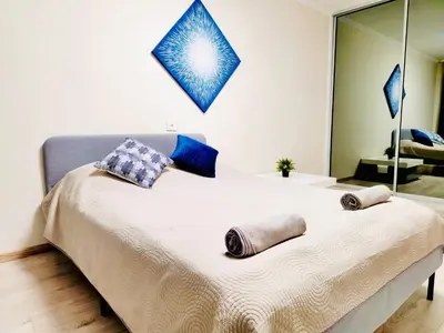 a bedroom with a large bed with pillows and a mirror at M&M Apartment V SELF CHECK-IN in Panevėžys