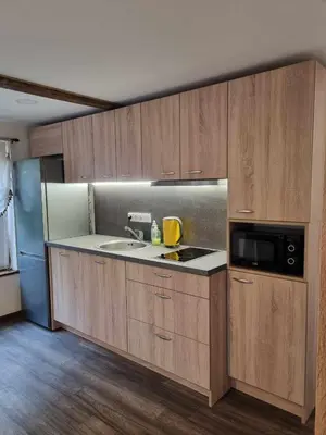 a kitchen with wooden cabinets and a sink and a microwave at ODM&A apartment in Vilnius