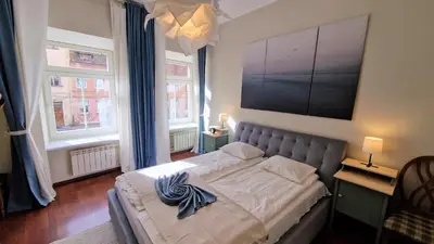 a bedroom with a bed with a large painting on the wall at Rudi4 Luxury Vilnius Apartment in Vilnius