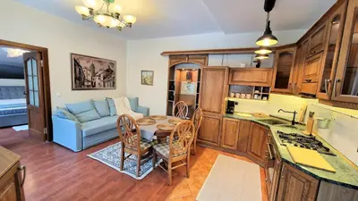 a kitchen and living room with a table and a couch at Rudi4 Luxury Vilnius Apartment in Vilnius