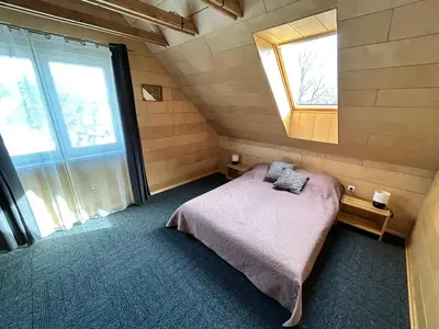a bedroom with a bed in a room with a window at Barn Guest House in Kazitiškis