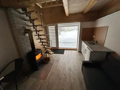 a kitchen with a stove and a staircase in a room at Barn Guest House in Kazitiškis
