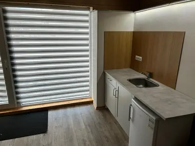 a kitchen with a sink and a large window at Barn Guest House in Kazitiškis