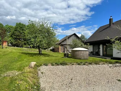 a house with a yard next to a building at Barn Guest House in Kazitiškis