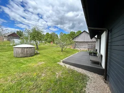 a backyard with a wooden deck and a gazebo at Barn Guest House in Kazitiškis