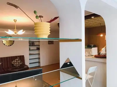 a kitchen with a glass shelf with a plant in a vase at Erdvus butas su balkonu šalia ežero ir stadiono in Visaginas