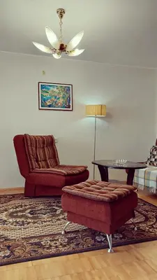 a living room with a couch and a chair and a table at Erdvus butas su balkonu šalia ežero ir stadiono in Visaginas