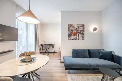 a living room with a blue couch and a table at Brand New Downtown Apartments by Reside Baltic in Vilnius
