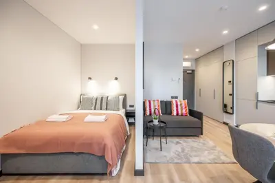 a bedroom and a living room with a bed and a couch at Brand New Downtown Apartments by Reside Baltic in Vilnius