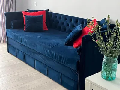 a blue couch with red and blue pillows on it at City Life in Vilnius