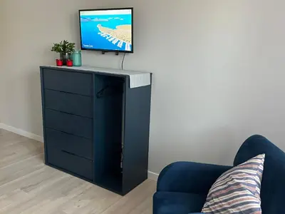 a tv on top of a black dresser in a living room at City Life in Vilnius