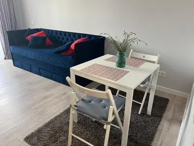 a table and chairs in a living room with a couch at City Life in Vilnius