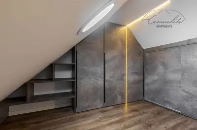 an attic room with a closet and a wall at Spacious sky Carmelite apartment in Vilnius
