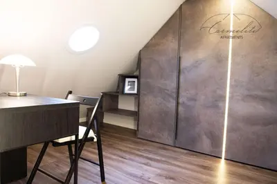 a room with a desk and a large metal door at Spacious sky Carmelite apartment in Vilnius