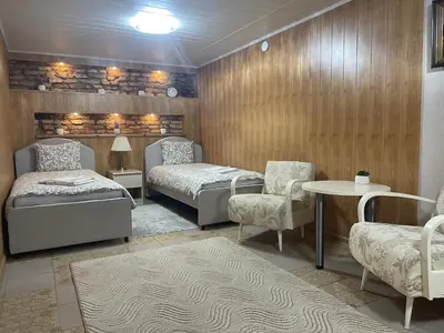 a room with two beds and a table and chairs at Guest House Vilnius in Vilnius