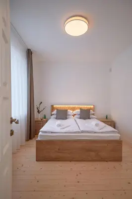 a bedroom with a large bed with a wooden headboard at Jonavos alpakų svečių namai in Jonava