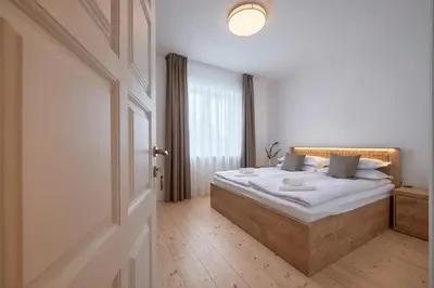 a bedroom with a bed with white sheets and a window at Jonavos alpakų svečių namai in Jonava
